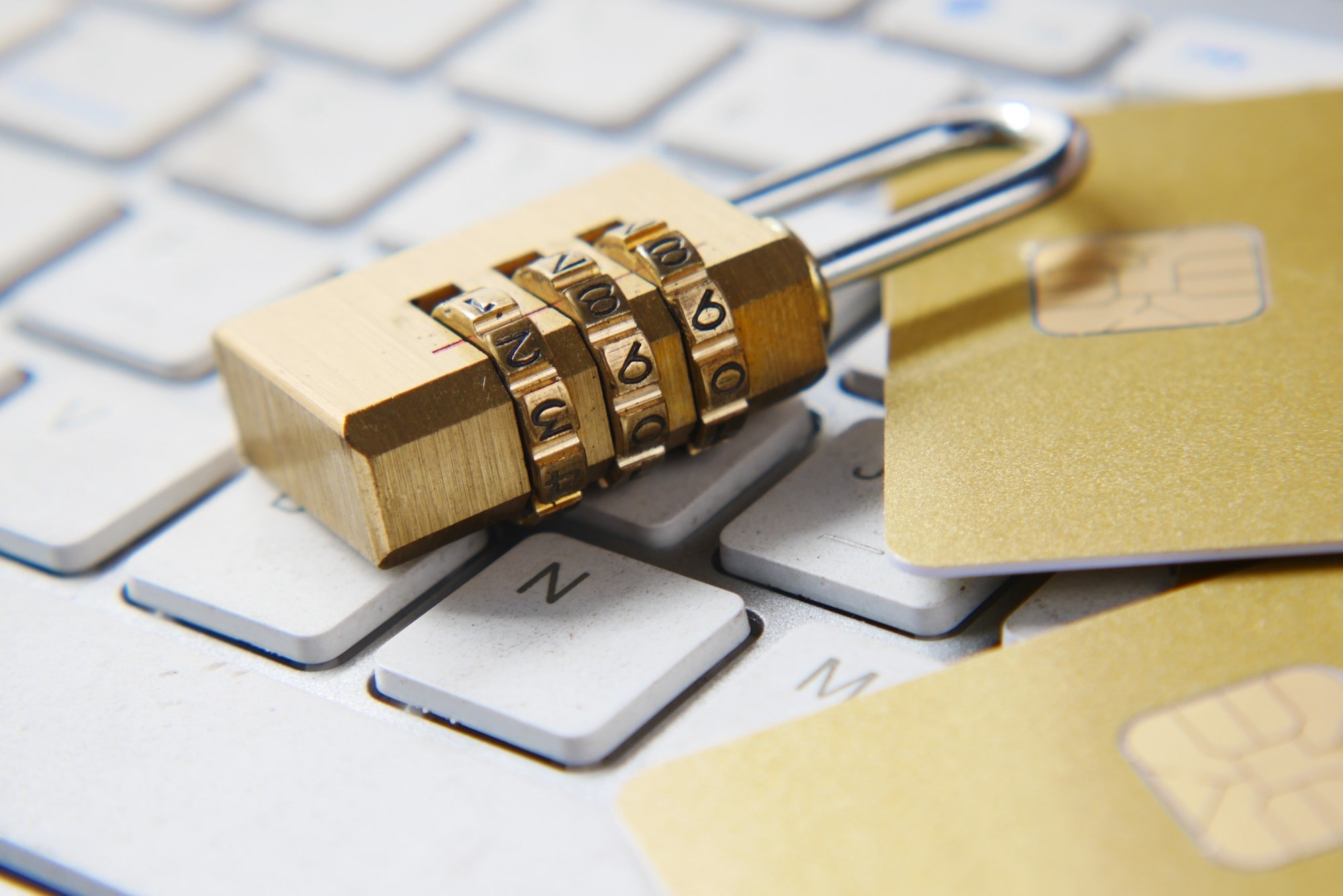 A number pattern padlock on a keyboard beside 2 cards representing security and privacy for the stakeholders of brand.